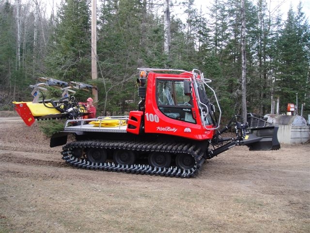 Red tracked snowmobile trail groomer in the town of Minocqua